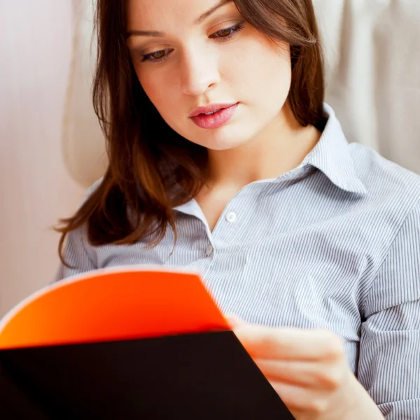 Молодая сексуальная женщина дома читает книгу — стоковое фото