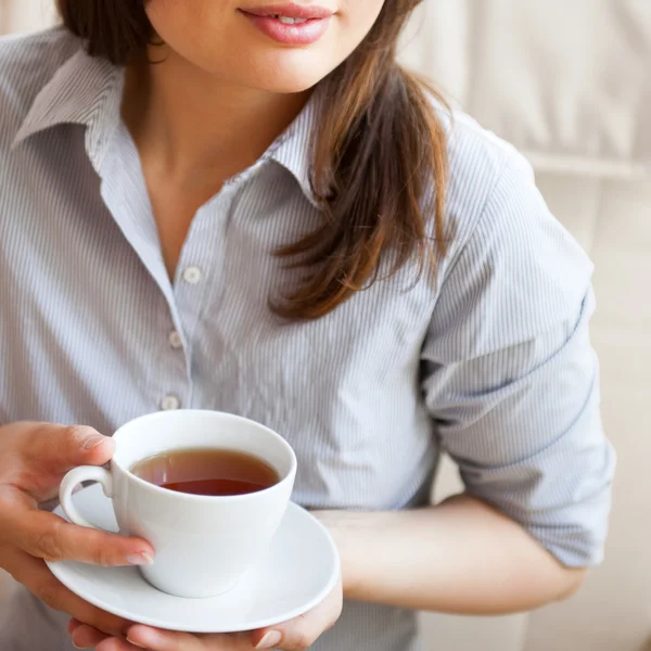 Jonge vrouw thuis nippen thee uit een kopje — Stockfoto