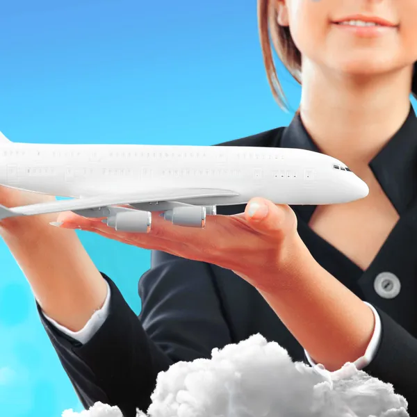 Portrait of young happy woman stewardess holding jet aircraft in — Stock Photo, Image