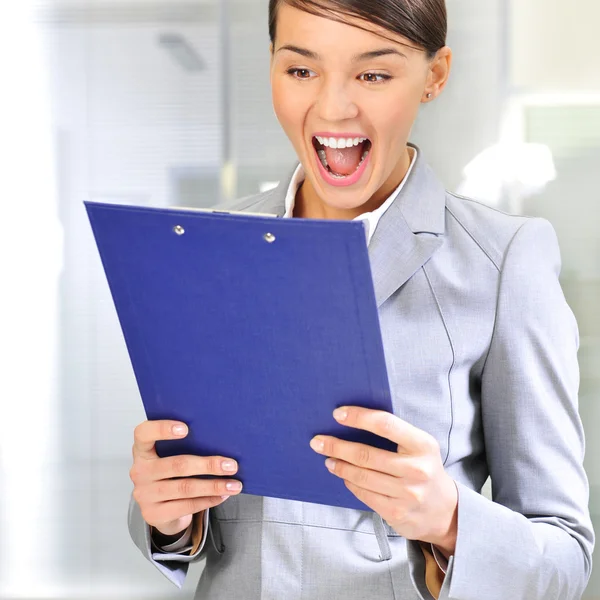 Portrait if young business woman at her office holding report — Stock Photo, Image