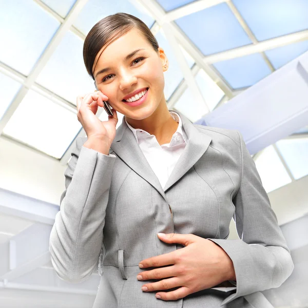 Porträt der schönen Geschäftsfrau am Telefon bei modernem Bau — Stockfoto
