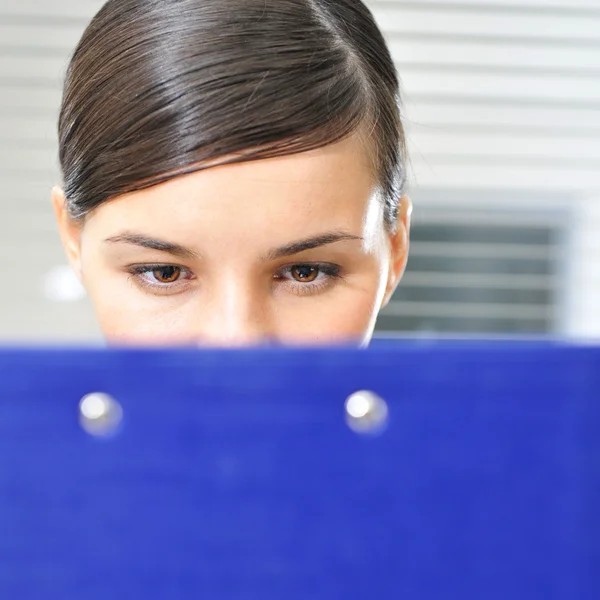 A portrait of a young business woman in an office with documents — Stock Photo, Image