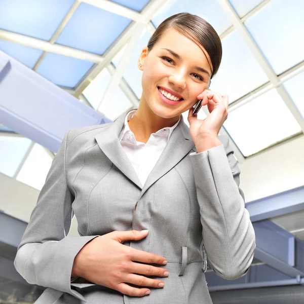 Retrato de una hermosa mujer de negocios en el teléfono en el edificio moderno —  Fotos de Stock