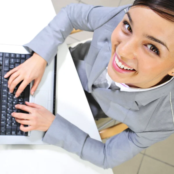 她的办公室在便携式计算机上的年轻商业女人。工作 — 图库照片