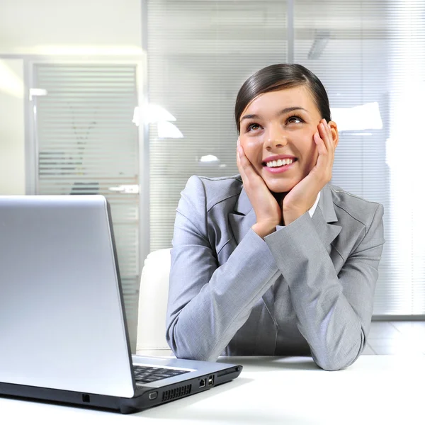 Fiatal üzleti nő egy laptop őt az irodában. arról ábrándozik — Stock Fotó