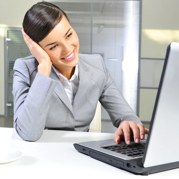 Jonge zakenvrouw op een laptop bij haar kantoor. werken — Stockfoto