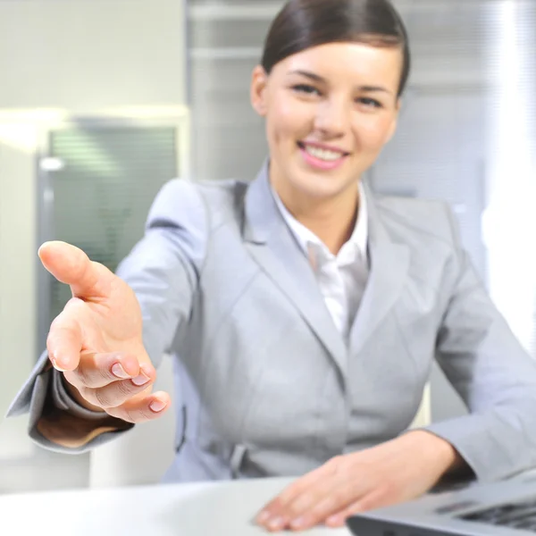 Mulher de negócios dá um aperto de mão em seu escritório — Fotografia de Stock