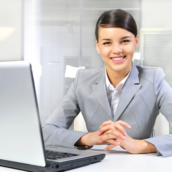 她的办公室在便携式计算机上的年轻商业女人 — 图库照片