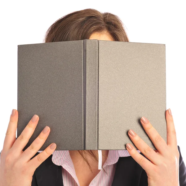 Unga leende studerande kvinna gömmer sig under bok. över vit bakgrunds — Stockfoto