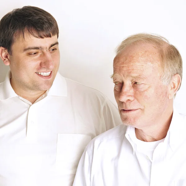 Twee mannen in woonkamer staande tegen de muur glimlachen — Stockfoto