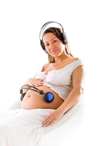 Zwangere vrouw luisteren naar muziek — Stockfoto