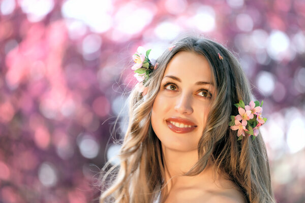 Pretty woman among a spring blossom tree