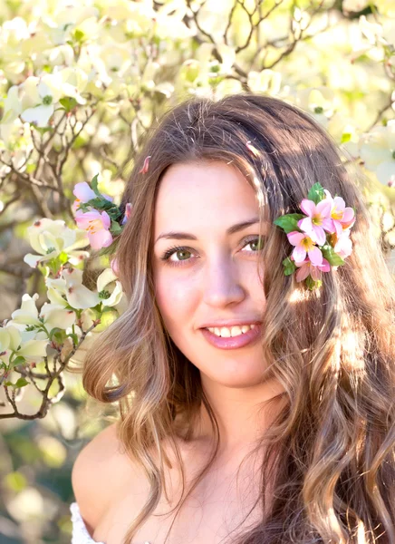 Mooie vrouw onder een voorjaar bloeien — Stockfoto