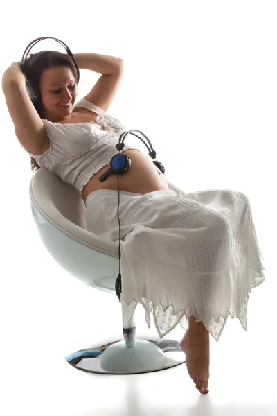 Terhes nő, zenehallgatás — Stock Fotó