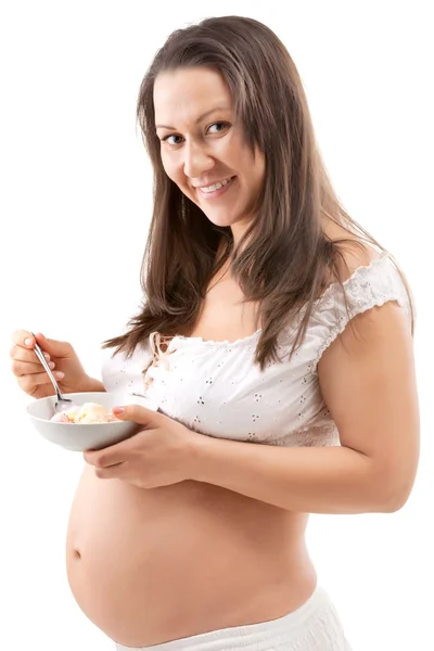 Беременная женщина ест кусочки апельсинов — стоковое фото