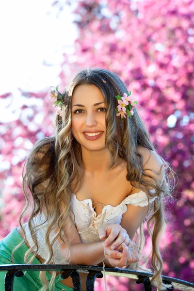 Pretty woman among a spring blossom — Stock Photo, Image