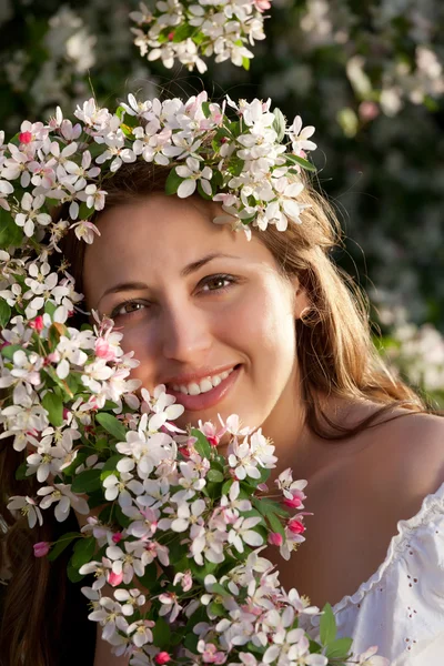 Pretty woman among a spring blossom — Stock Fotó