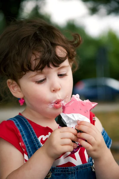 Menina está comendo sorvete de morango — Fotografia de Stock