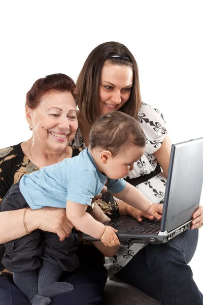Бабушка и мама с ребенком с ноутбуком — стоковое фото