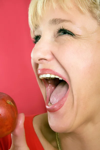 Blonde Frau mit einem Pfirsich auf einem roten — Stockfoto