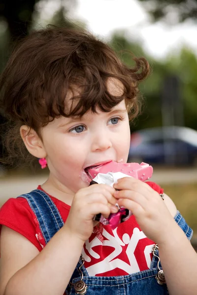 Niña está comiendo helado de fresa — Foto de Stock