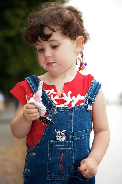 Little girl is eating strawberry ice-cream — Stock Photo, Image