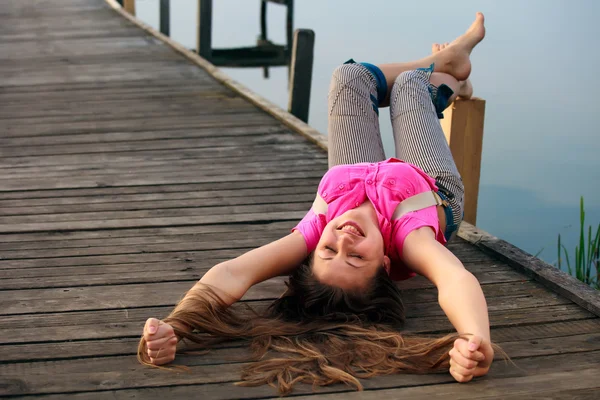 Pihentető fiatal nő feküdt a híd — Stock Fotó