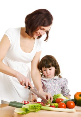 Mother and daughter cooking at the kitchen clipart