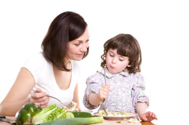 Mother and daughter cooking at the kitchen clipart