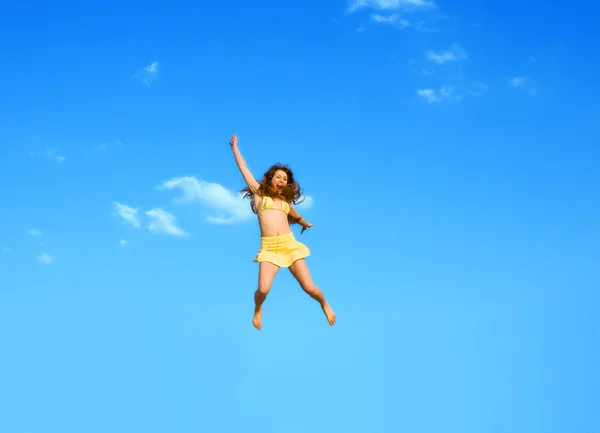 Happy jumping girl sur un fond de ciel bleu — Photo