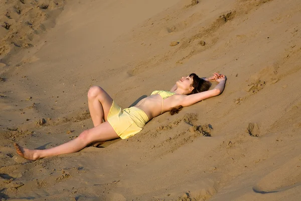 Blond tjej ligga på stranden — Stockfoto