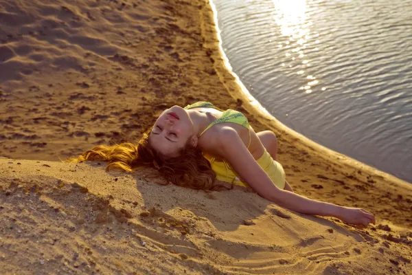 ブロンドの女の子がビーチで横になっています。 — ストック写真