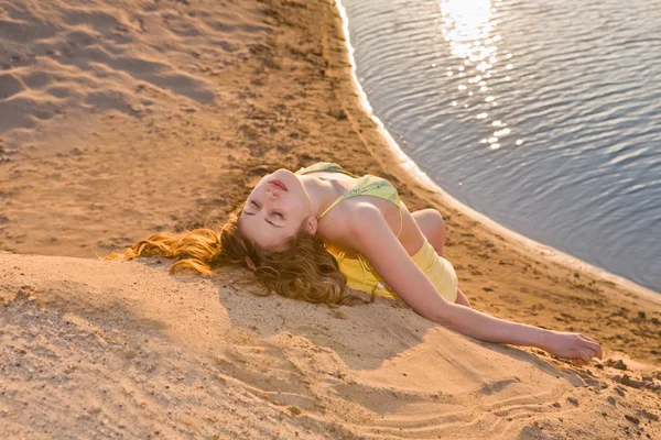 ブロンドの女の子がビーチで横になっています。 — ストック写真