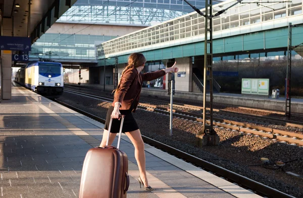 Young lady with luggage stop a train — Stock Photo, Image