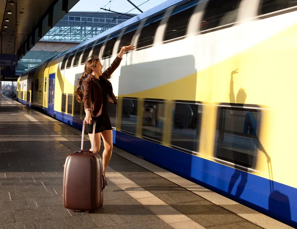 Junge Frau mit Gepäck stoppt Zug — Stockfoto