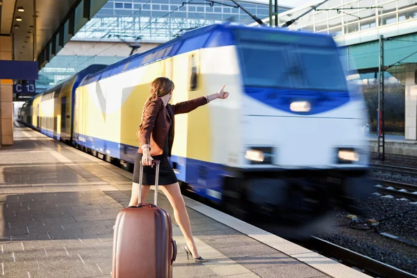 stock image Young lady with luggage stop a train