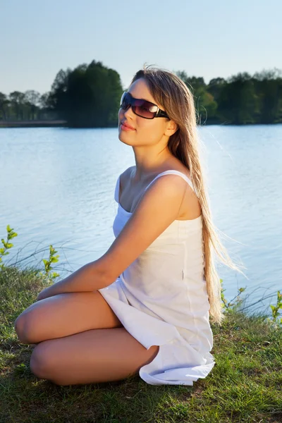Mujer joven en gafas de sol sobre fondo de agua —  Fotos de Stock