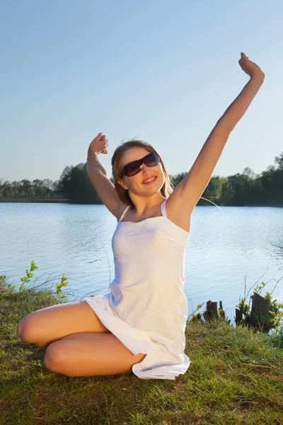 Fiatal nő a víz háttér napszemüveg — Stock Fotó