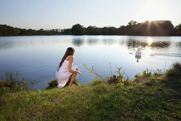 水の背景と白鳥に金髪の女性 — ストック写真