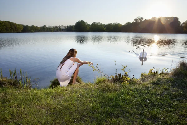Mujer rubia sobre fondo de agua y cisne — Foto de Stock