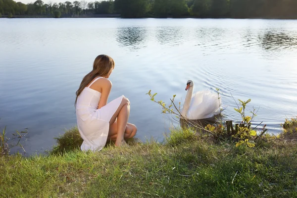 Donna bionda sullo sfondo dell'acqua e cigno — Foto Stock