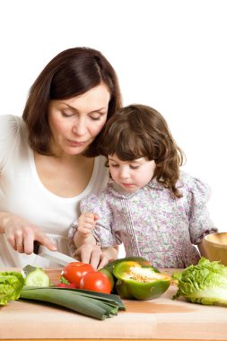 Mother and daughter cooking at the kitchen clipart