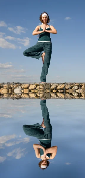 Una donna che fa yoga sopra l'acqua — Foto Stock