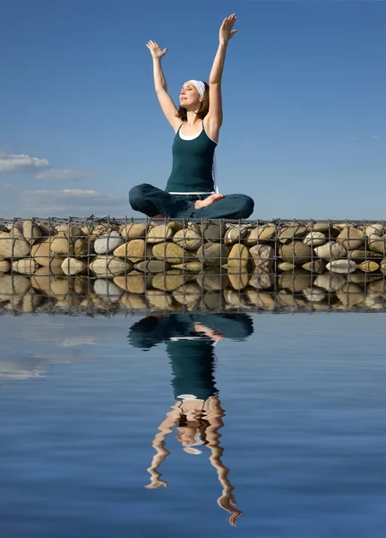 Une femme faisant du yoga au-dessus d'une eau — Photo