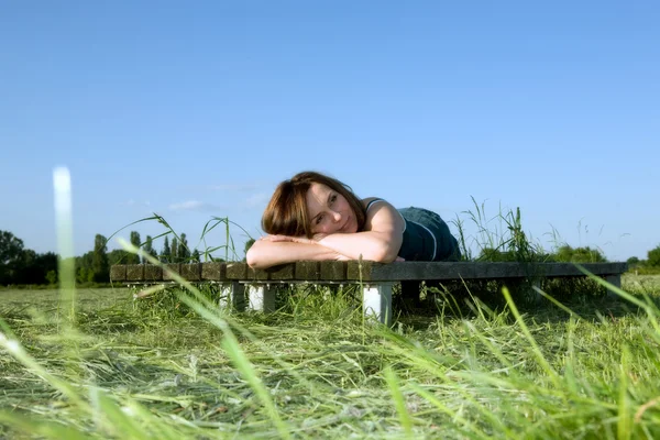 Yeşil çimenlerin üzerinde güzel bir kadın yatıyor — Stok fotoğraf