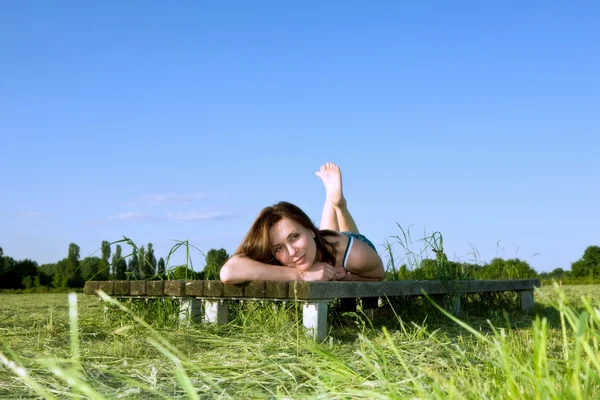 Yeşil çimenlerin üzerinde güzel bir kadın yatıyor — Stok fotoğraf