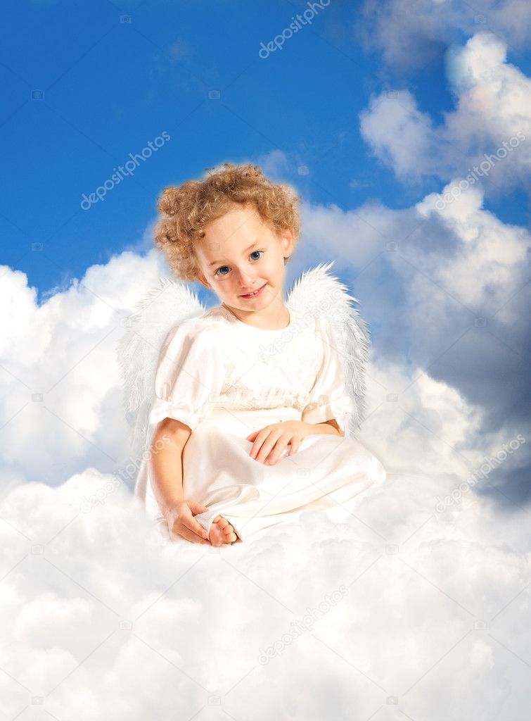 Little girl with fairy wings lies on a cloud