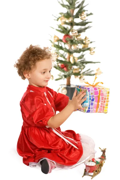 Glückliches kleines Mädchen mit einem Weihnachtsgeschenk — Stockfoto