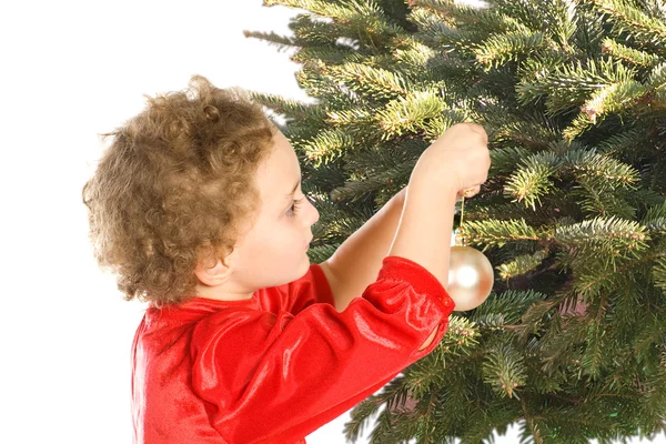 Mädchen hängt Weihnachtsschmuck an den Baum — Stockfoto