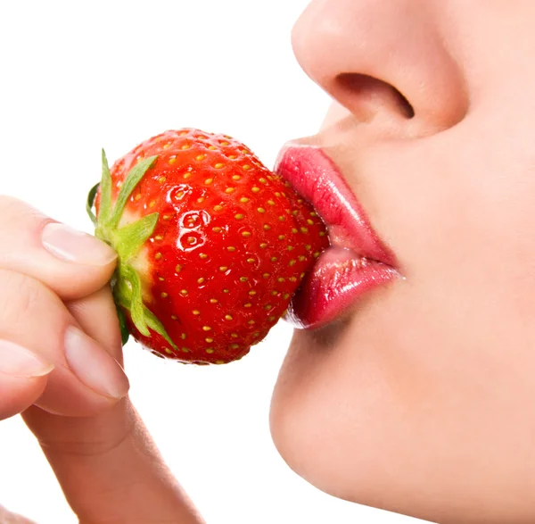 Primer plano de una joven boca de niña con una fresa — Foto de Stock